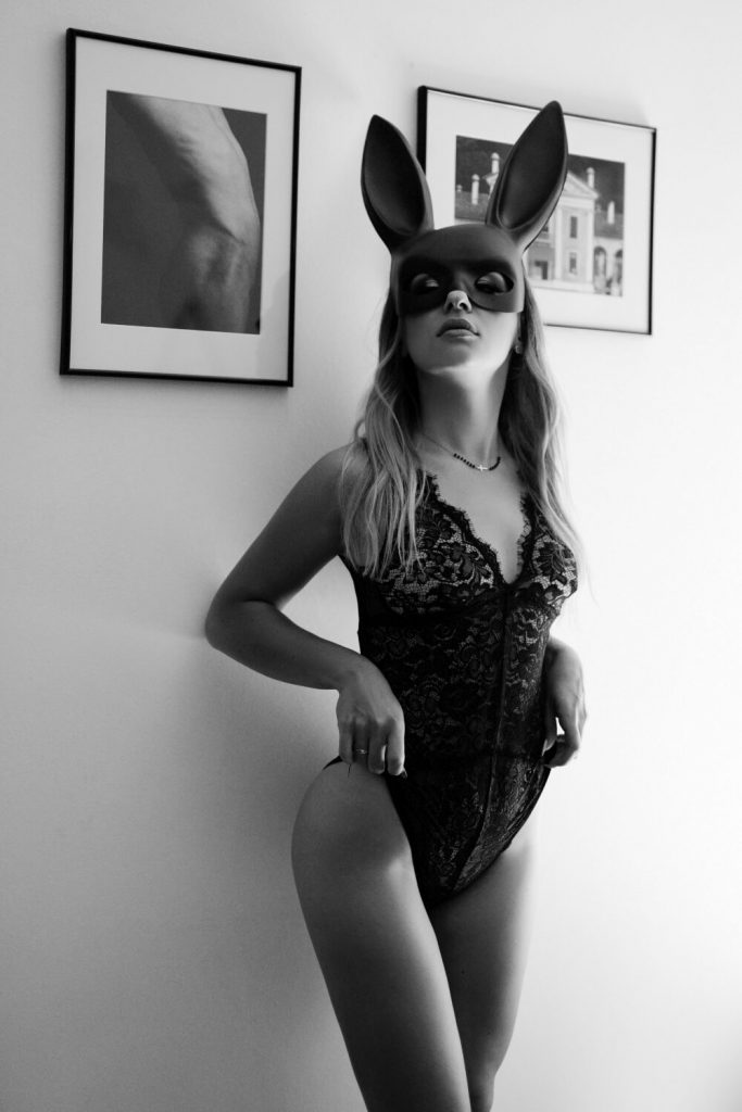 zdjęcie kobiece w ciemnym koronkowym body w masce królika