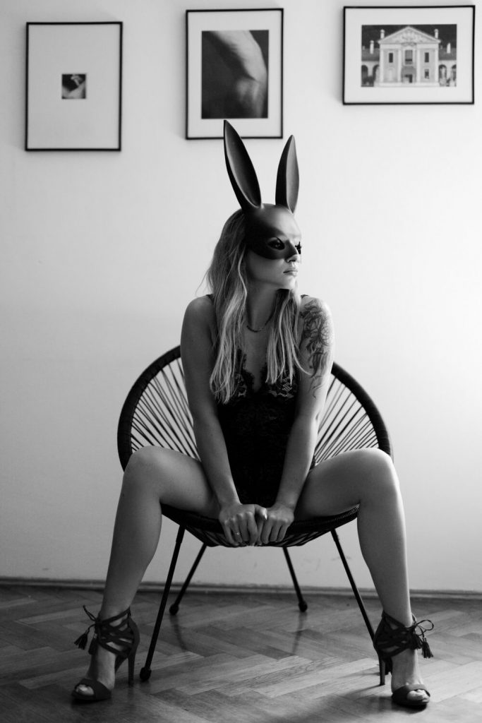zdjęcie seksownej kobiety siedzącej na fotelu w masce króliczka