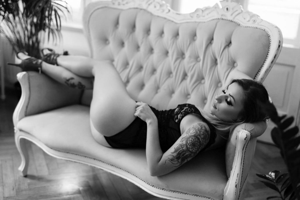 zdjęcie sensualne kobiety leżącej na pikowanej sofce